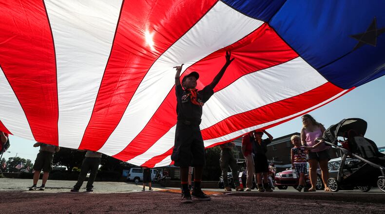 JaNoah Master, 7, a Cub Scout with pack 473, helps hold up the flag during The Marietta Freedom Parade on Wednesday July 4, 2018.