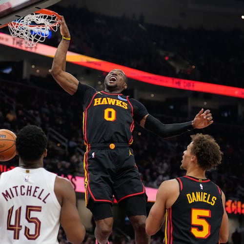 Atlanta Hawks forward Jonathan Kuminga (0) dunks in front of Cleveland Cavaliers guard Donovan Mitchell (45) and teammate Dyson Daniels (5) in the second half of an NBA basketball game in Cleveland, Wednesday, April 8, 2026. (AP Photo/Sue Ogrocki)