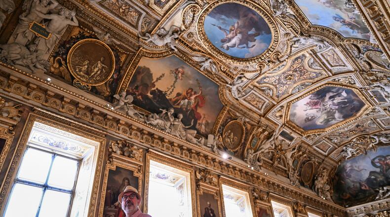 A visitor looks on during the reopening to the public of the Apollo Gallery, at the Louvre museum in Paris, Wednesday, July 22, 2026. (Lou Benoist/Pool Photo via AP)