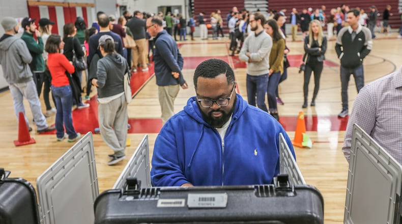 Ken Hammond votes and the long line wraps around the gym behind him on Tuesday, Nov. 8, 2016, at Henry W. Grady High School in Atlanta. JOHN SPINK /JSPINK@AJC.COM