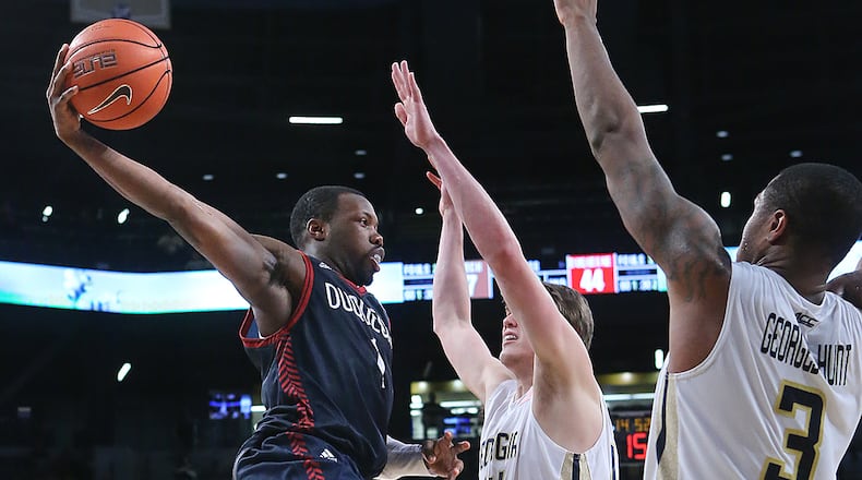 122915 ATLANTA: Duquesne guard Derrick Colter looks to pass on a double team by Georgia Tech Defenders Ben Lammers (center) and Marcus Georges-Hunt in a basketball game on Tuesday, Dec. 29, 2015, in Atlanta. Curtis Compton / ccompton@ajc.com