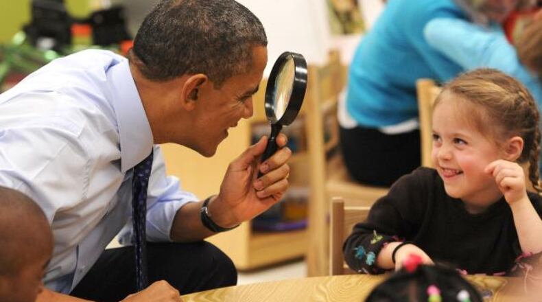President Barack Obama uses a spy glass to play with a Decatur student during a 2013 visit to Georgia. JOHNNY CRAWFORD / JCRAWFORD@AJC.COM