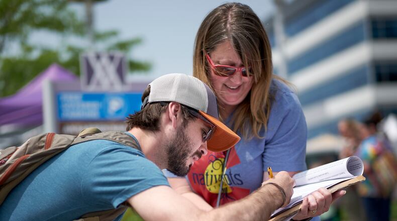 FILE- In this June 2, 2019 file photo, a volunteer in Omaha Neb., collects signatures for a petition to place a medical marijuana measure on the Nebraska 2020 ballot. Petition drives to legalize medical marijuana, allow casino gambling and lower property taxes face an uncertain future now that the new coronavirus has forced group leaders to stop collecting signatures. The groups are waiting for the pandemic to subside, but some said they still believe they can qualify for the 2020 ballot. (AP Photo/Nati Harnik, File)