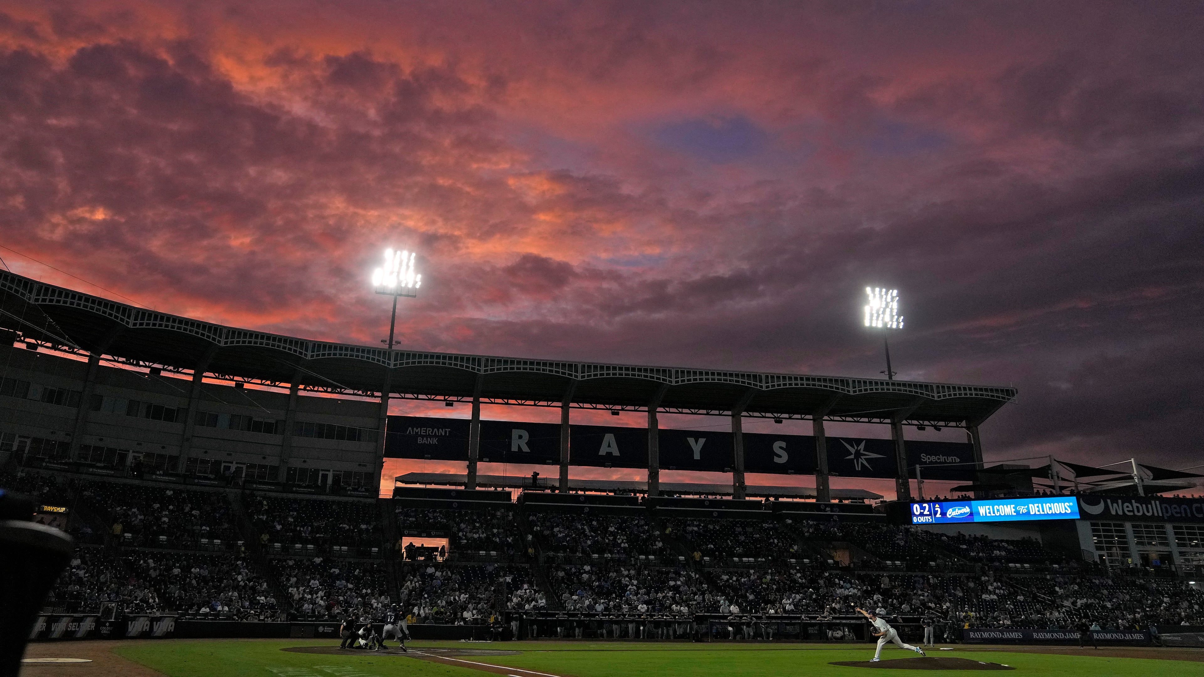 The sun sets over Steinbrenner Field during the second inning of a baseball game between the Tampa Bay Rays and the Seattle Mariners Wednesday, Sept. 3, 2025, in Tampa, Fla. (AP Photo/Chris O'Meara)