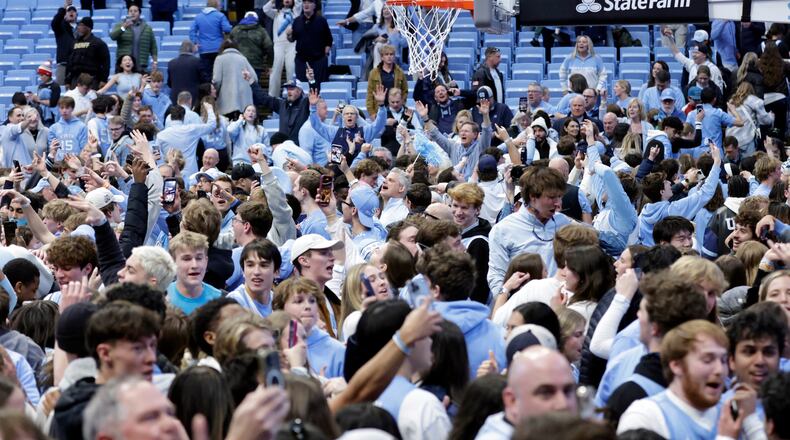North Carolina fans take the floor and celebrate after the team defeated Duke in the final seconds of an NCAA college basketball game Saturday, Feb. 7, 2026, in Chapel Hill, N.C. (AP Photo/Chris Seward)