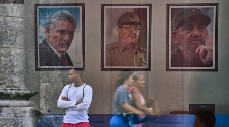 Images of Cuba's President Miguel Diaz-Canel, Raul Castro, and Fidel Castro, are seen at the state building in Havana, Cuba, Wednesday, May 20, 2026. (AP Photo/Ramon Espinosa)