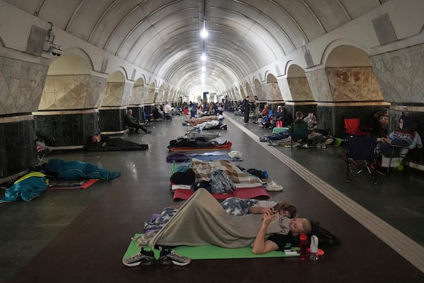 People rest in a metro station, being used as a bomb shelter, during a Russian attack in Kyiv, Ukraine, early Thursday, July 10, 2025. (AP Photo/Efrem Lukatsky)