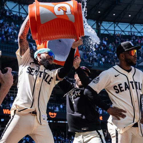 Seattle Mariners' J.P. Crawford, left, douses Victor Robles, second from right, after a baseball game against the Arizona Diamondbacks, Sunday, May 31, 2026, in Seattle. (AP Photo/Stephen Brashear)