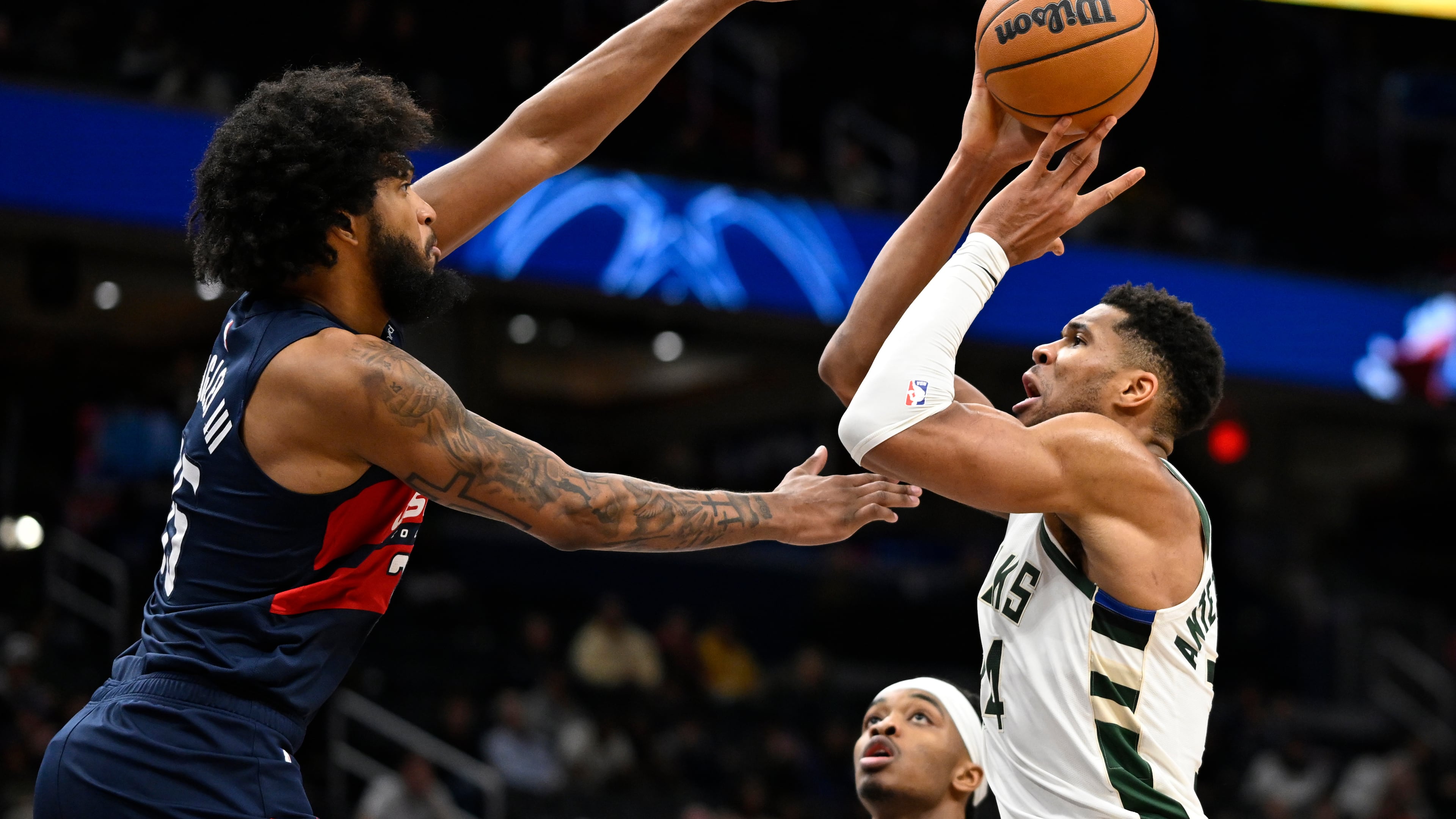Milwaukee Bucks forward Giannis Antetokounmpo, right, prepares to score over Washington Wizards forward Marvin Bagley III, left, during the second half of an NBA basketball game Monday, Dec. 1, 2025, in Washington. (AP Photo/John McDonnell)