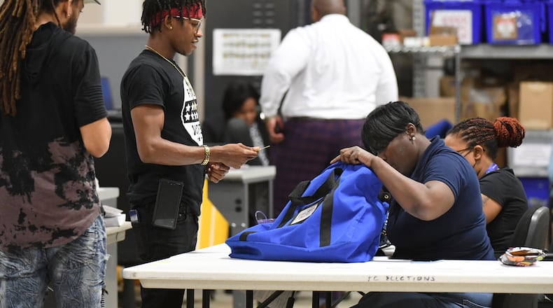 An election worker checks memory cards contained votes at Fulton County Election Preparation Center on Tuesday, May 24, 2022. (Hyosub Shin / Hyosub.Shin@ajc.com)