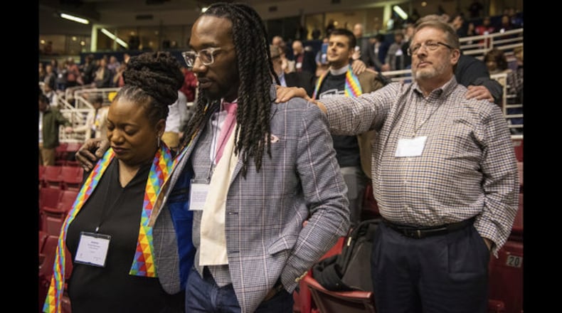 Adama Brown-Hathasway (left), the Rev. Dr. Jay Williams, both from Boston, and Ric Holladay of Kentucky join in prayer during the 2019 Special Session of the General Conference of the United Methodist Church in St. Louis, Mo., Tuesday, Feb. 26, 2019. The result of the crucial meeting was a strengthening of bans on same-sex marriage and ordination of LGBT clergy. Sid Hastings / Associated Press