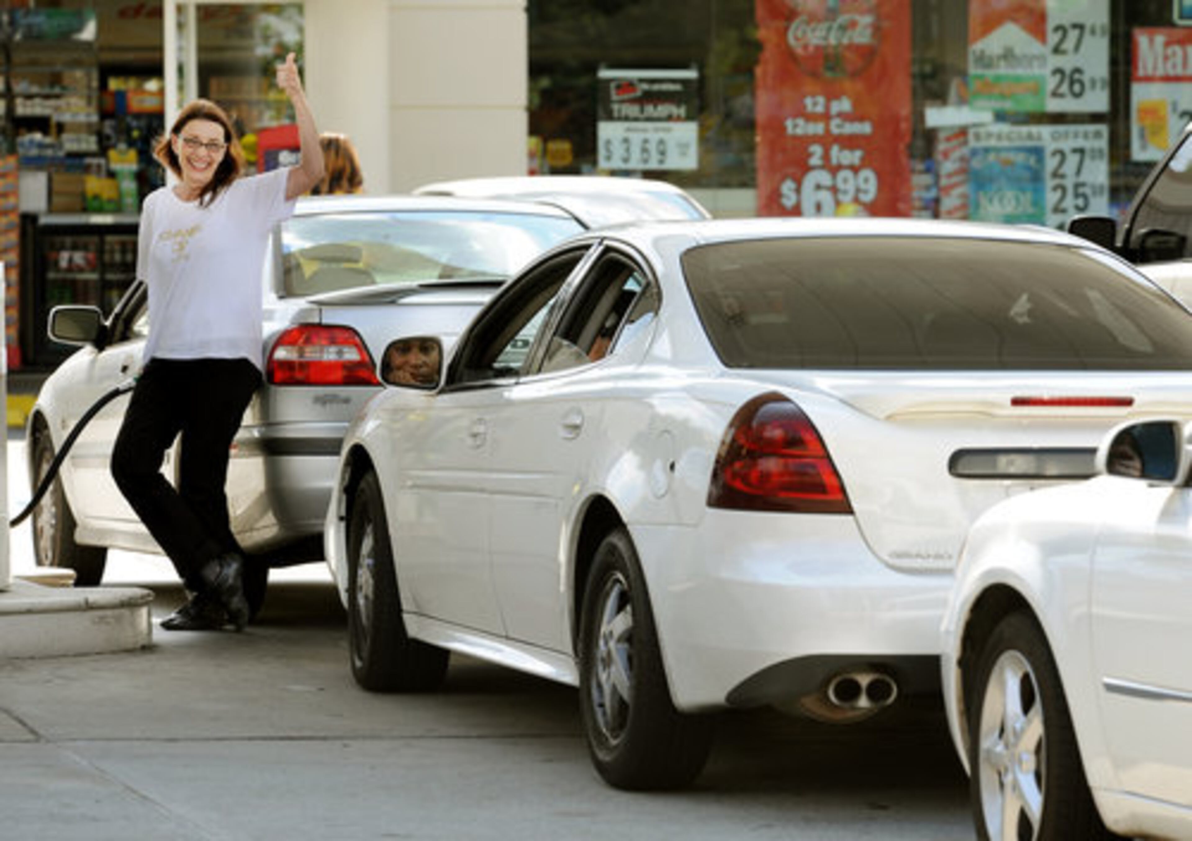 Sept. 2008 -- Some lucky motorists were able to find gas around town. Elizabeth Jackson of Midtown signaled 'all is good' as she filled up her car at the BP Station at North Avenue and Spring Street.