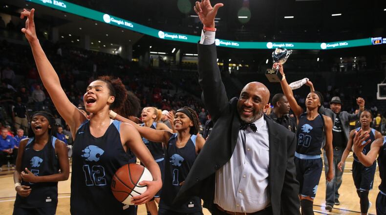 March 9, 2018 - Atlanta, Ga: Lovejoy coach Cedric King, right, guard J'Auana Robinson (12) and other players celebrates their win against Harrison during the GHSA Class AAAAAA Girls State Championship at McCamish Pavilion Friday, March 9, 2018, in Atlanta. Lovejoy won 57-41. PHOTO / JASON GETZ