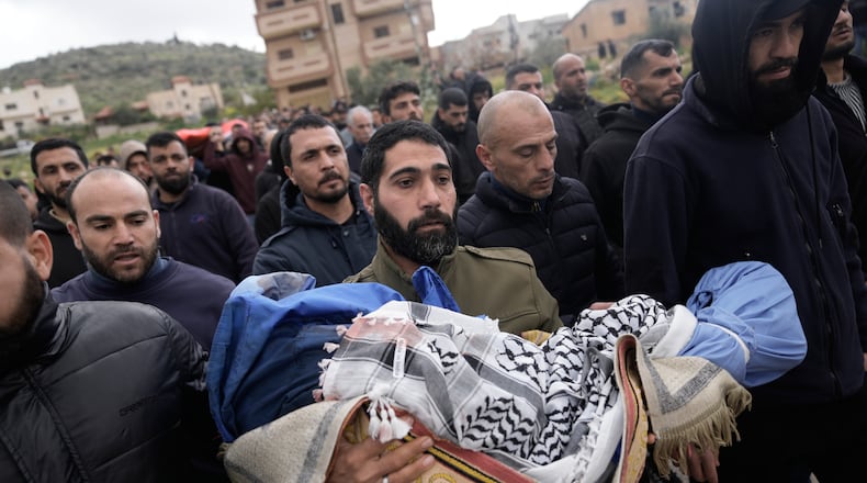 A Palestinian man carries Muhammad Bani Odeh, 5, at the funeral of four members of the Odeh family who were killed in their car by Israeli security forces during an army operation in Tammun, West Bank, Sunday, March 15, 2026. (AP Photo/Majdi Mohammed)