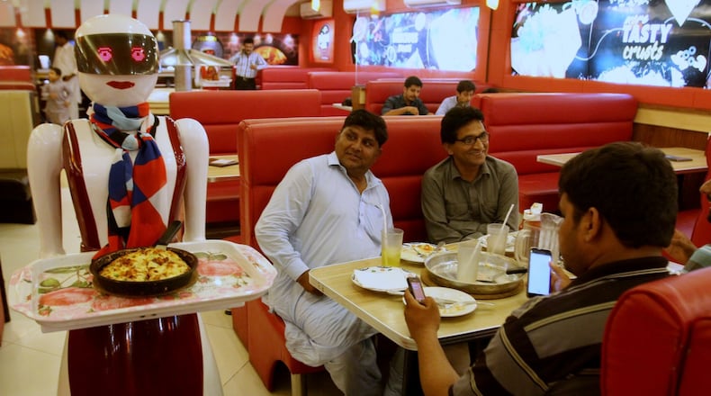 A robot waitress delivers food at Pizza.com in Multan, Pakistan, on Tuesday.