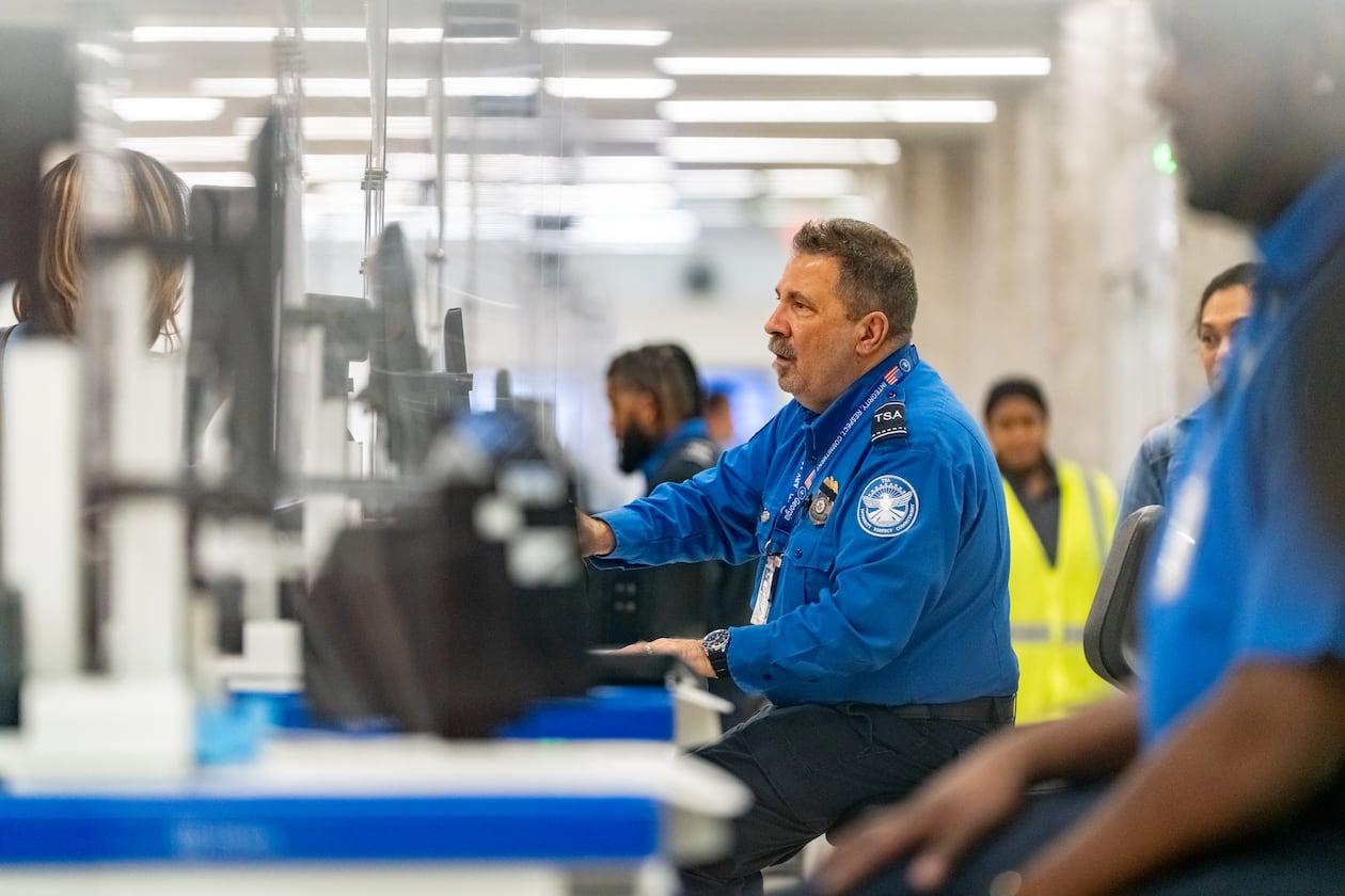 A Transportation Security Administration officer checks the identification of travelers at Hartsfield-Jackson Atlanta International Airport on Wednesday, Oct. 1, 2025. (Ben Hendren for the AJC)