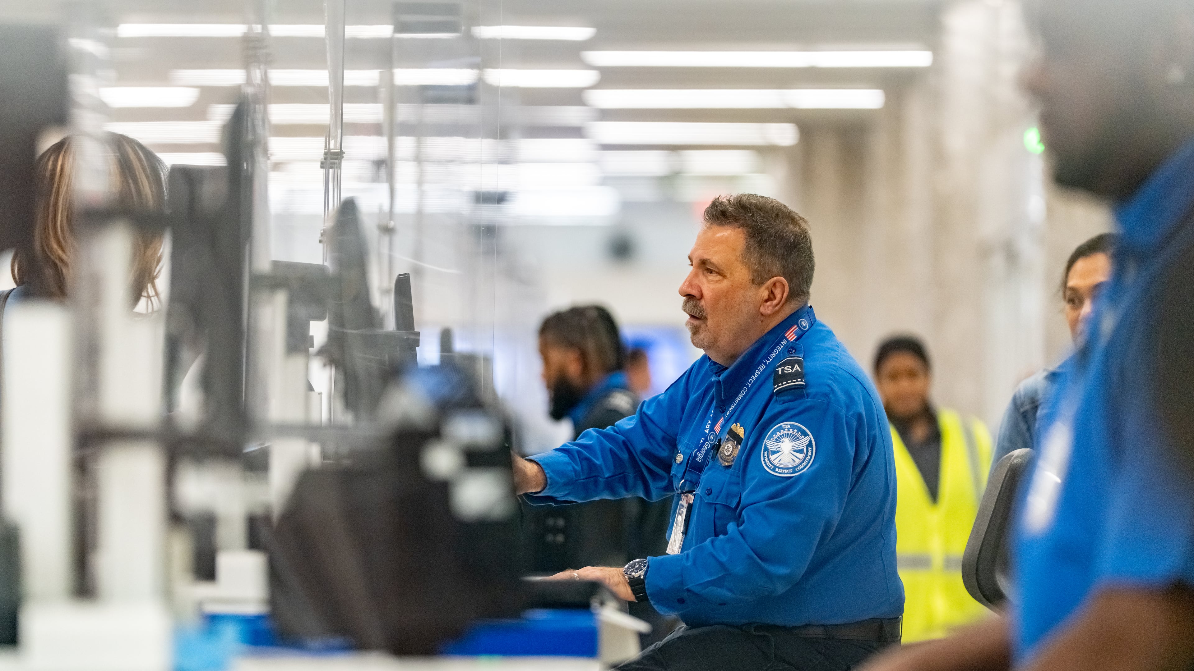 A Transportation Security Administration officer checks the identification of travelers at Hartsfield-Jackson Atlanta International Airport on Wednesday, Oct. 1, 2025. (Ben Hendren for the AJC)