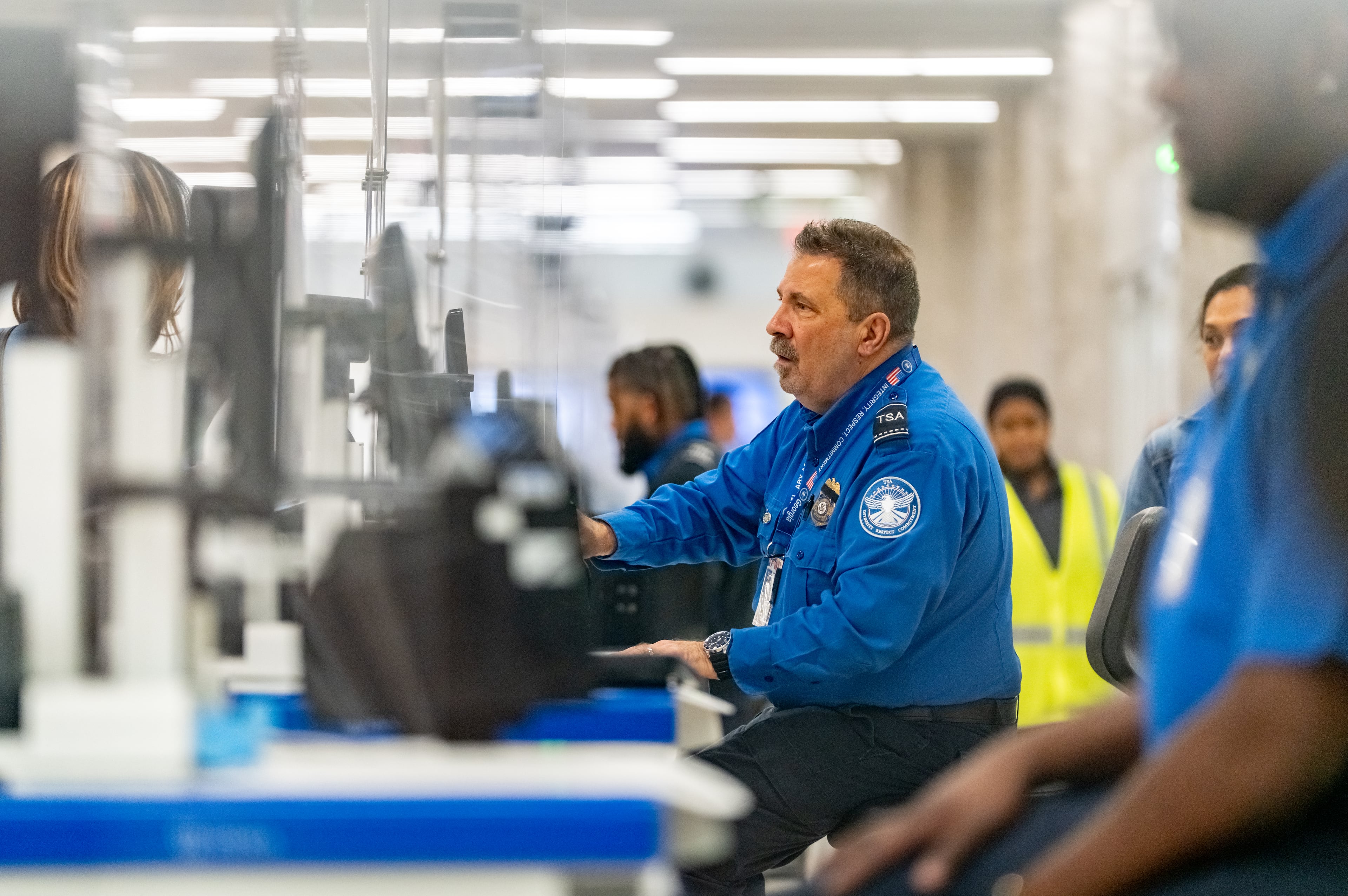 A Transportation Security Administration Agent checks the identification of travelers at Hartsfield-Jackson Atlanta International Airport.