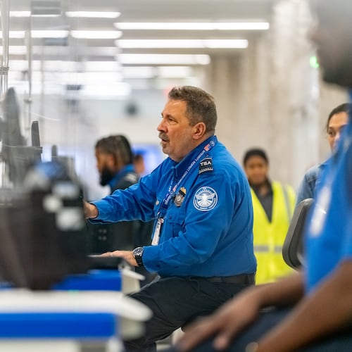 A Transportation Security Administration officer checks the identification of travelers at Hartsfield-Jackson Atlanta International Airport on Wednesday, Oct. 1, 2025. (Ben Hendren for the AJC)