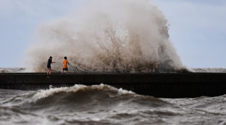 Children play near breaking waves on West End Pier on Lake Pontchartrain as Tropical Storm Bertha approaches the Louisiana Coast Wednesday, July 22, 2026, in New Orleans. (AP Photo/Gerald Herbert)