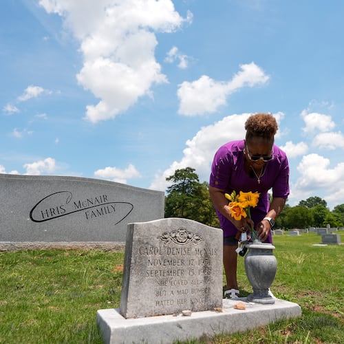 Lisa McNair arranges flowers on the grave of her late sister, Carol Denise McNair, Monday, June 1, 2026, in Birmingham, Ala. (AP Photo/Mike Stewart)
