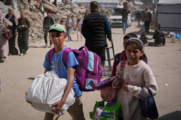 Palestinian children carry belongings as they leave the Shijaiyah neighborhood following evacuation warnings issued by the Israeli army, in Gaza City,on Thursday, April 3, 2025. (AP Photo/Jehed Alshrafi)