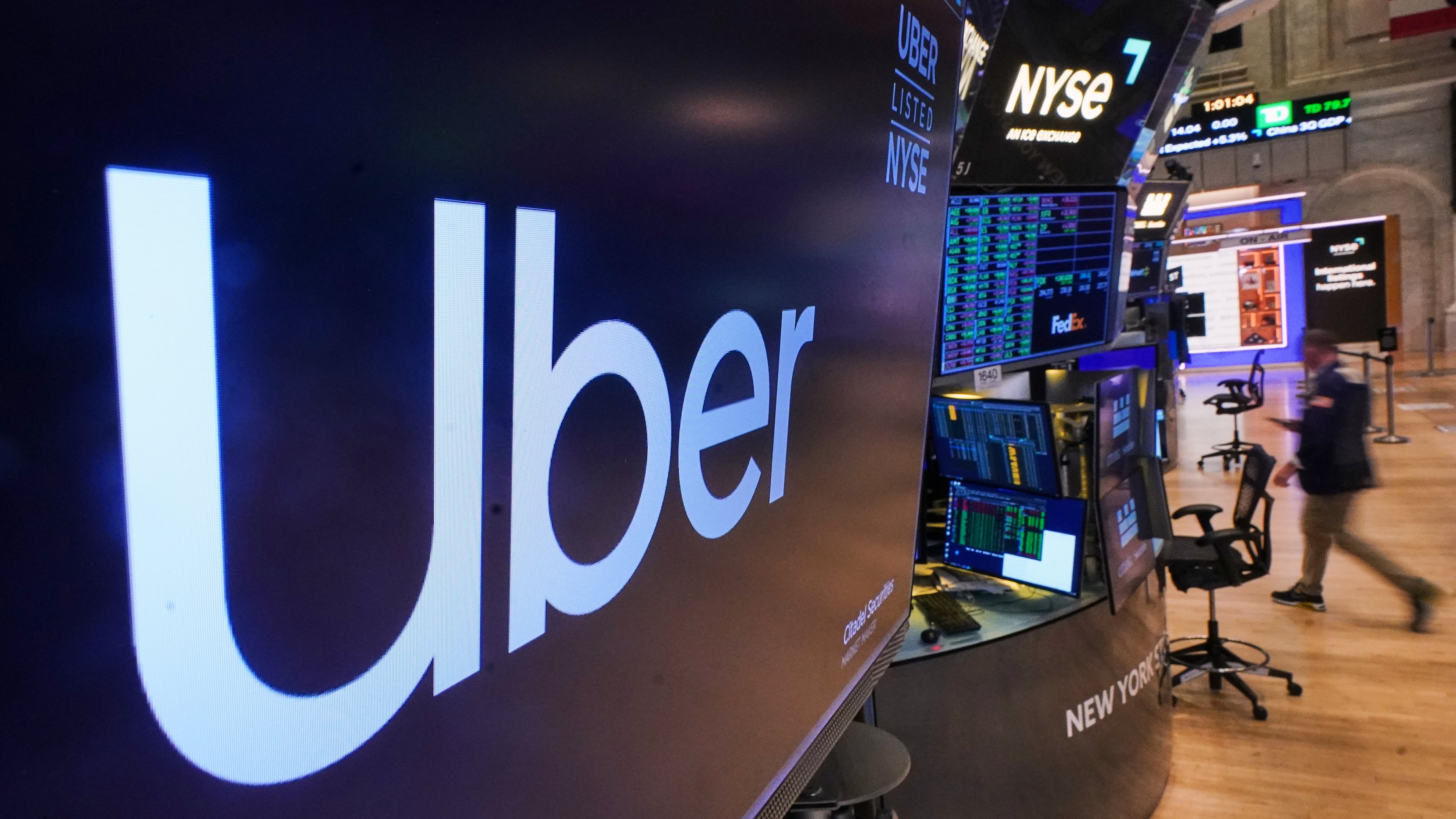 The logo for Uber is displayed above a trading post on the floor of the New York Stock Exchange, Monday, Oct. 20, 2025. (AP Photo/Richard Drew)