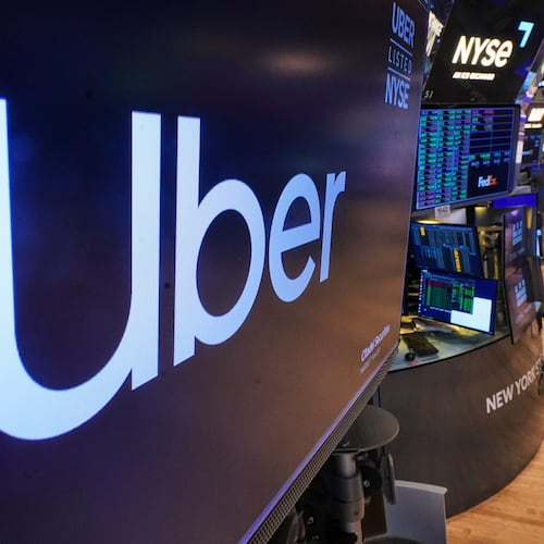 The logo for Uber is displayed above a trading post on the floor of the New York Stock Exchange, Monday, Oct. 20, 2025. (AP Photo/Richard Drew)