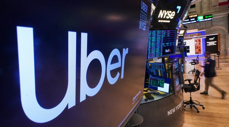 The logo for Uber is displayed above a trading post on the floor of the New York Stock Exchange, Monday, Oct. 20, 2025. (AP Photo/Richard Drew)