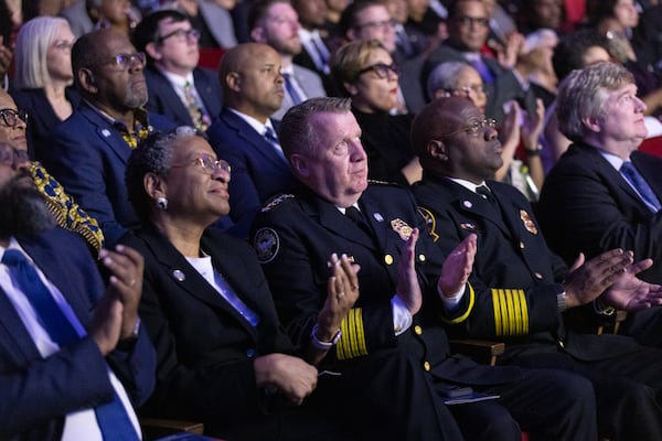 Atlanta Police Chief Darin Schierbaum (center) and Atlanta Fire Rescue Chief Roderick Smith clap during a video featuring the city’s new public safety training center before Mayor Andre Dickens gives the final State of the City address of his first term at the Woodruff Arts Center in Atlanta on Tuesday, Feb. 25, 2025. (Arvin Temkar/AJC)
