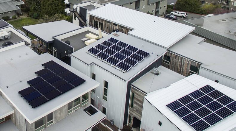 The Lakeview Solar Community in Kirkland, by Dwell Development and Medici Architects, is made up of two attached duplex units, left, and two single-family homes. “It’s a solar-ready community, and our shared driveway really feels like a community,” says homeowner Chris Voss. “There are themes between the four homes, but they’re not cookie-cutter; you can certainly tell they’re of the same mind.” (Steve Ringman/The Seattle Times/TNS)
