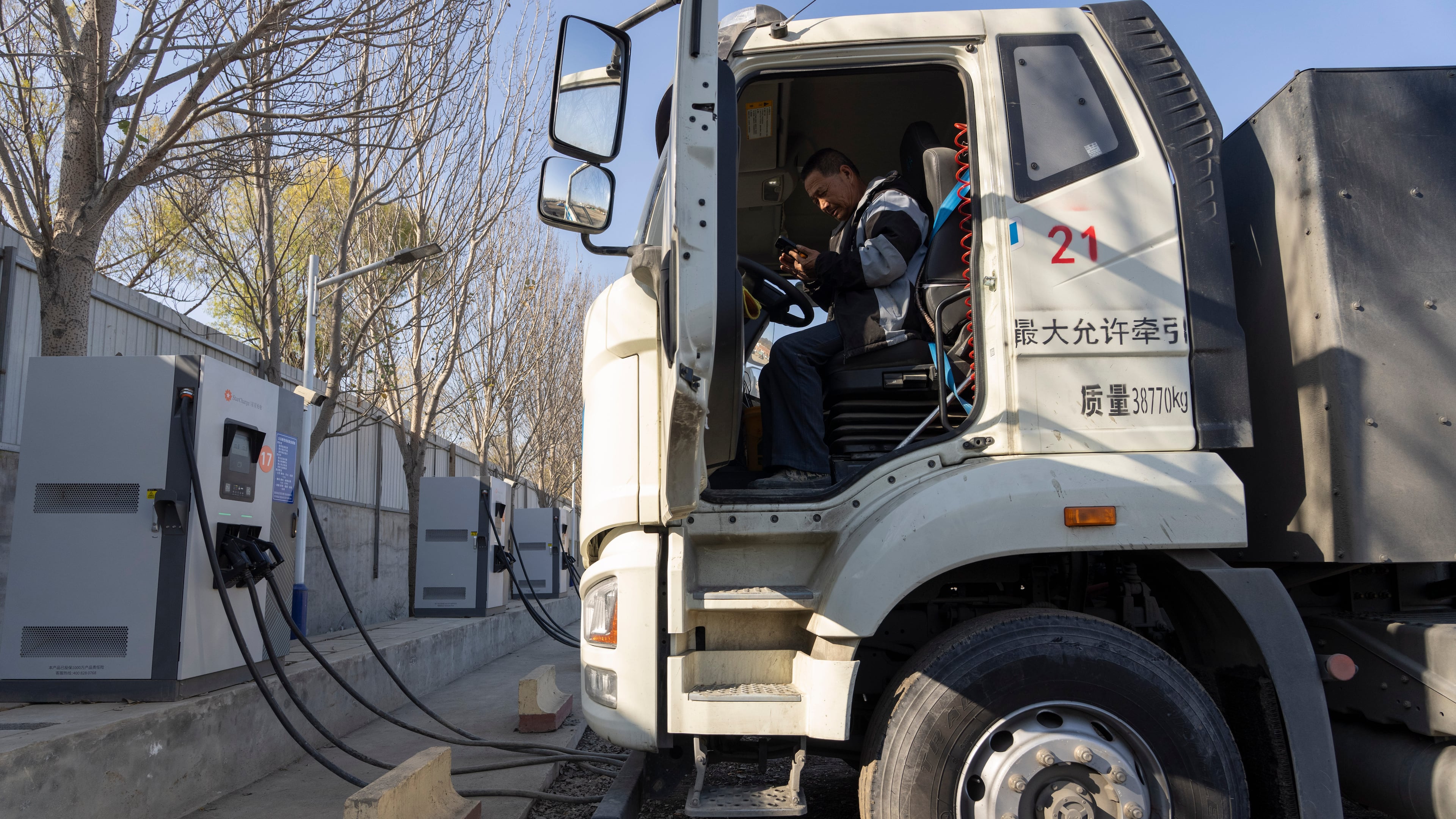 A driver sits in his electric truck at a charging station on the outskirts of Beijing, on Nov. 14, 2025. (AP Photo/Ng Han Guan)