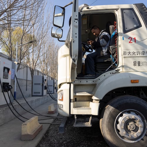 A driver sits in his electric truck at a charging station on the outskirts of Beijing, on Nov. 14, 2025. (AP Photo/Ng Han Guan)