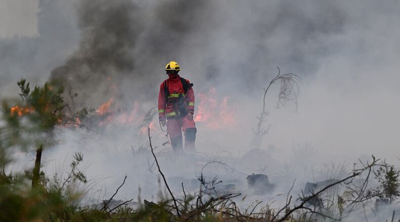 Firefighters battle a wildfire near Marcheprime, outside, Bordeaux, France, Sunday, July 26, 2026. (AP Photo/Emma Da Silva)