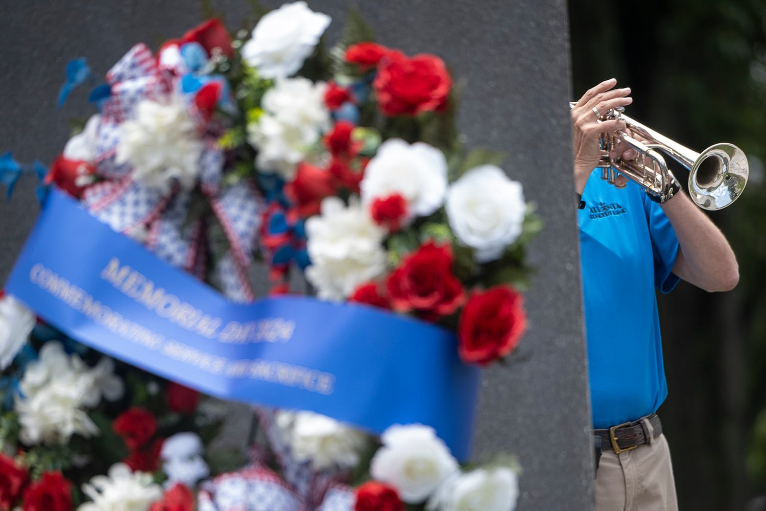 A member of the Atlanta Concert Band plays taps at the end of the Memorial Day ceremony at Marietta National Cemetery on Monday, May 27, 2024. (Ben Gray / Ben@BenGray.com)