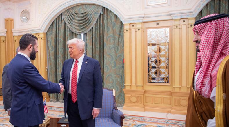 FILE - In this photo provided by the Saudi Royal Palace, Syria's interim President Ahmad al-Sharaa, left, shakes hands with U.S. President Donald Trump in Riyadh, Saudi Arabia, Wednesday, May 14, 2025. At foreground right is Saudi Crown Prince Mohammed bin Salman. (Bandar Aljaloud/Saudi Royal Palace via AP, File)