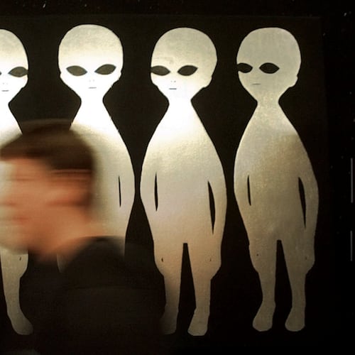 FILE - A patron passes a painting inside the International UFO Museum and Research Center in Roswell, N.M., on June 10, 1997. (AP Photo/Eric Draper, File)