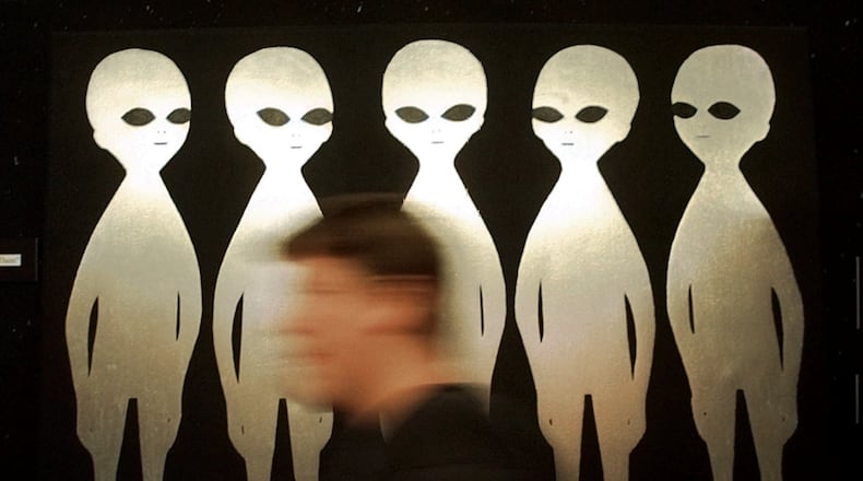 FILE - A patron passes a painting inside the International UFO Museum and Research Center in Roswell, N.M., on June 10, 1997. (AP Photo/Eric Draper, File)