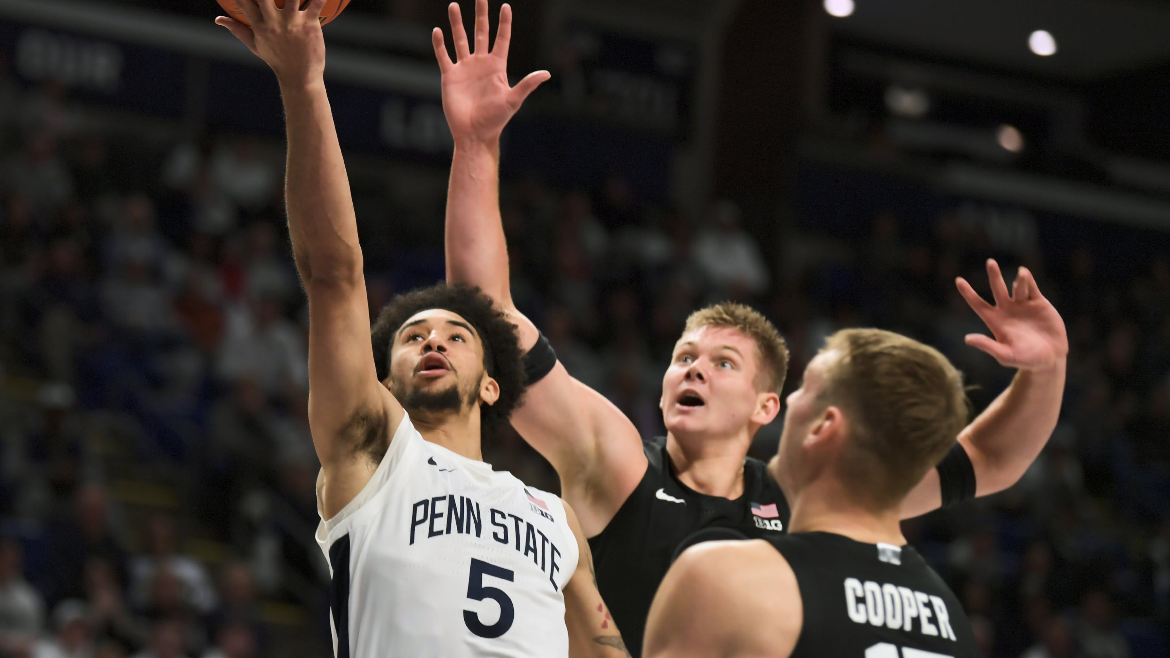 Michigan State's Jaxon Kohler, center, and Carson Cooper (15) attempt to block a shot by Penn State's Freddie Dilione V (5) during the first half of an NCAA college basketball game Saturday, Dec. 13, 2025, in State College, Pa. (AP Photo/Gary M. Baranec)
