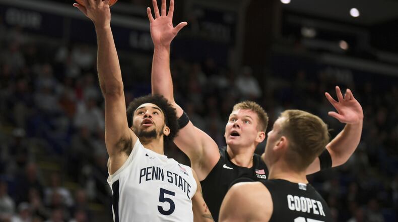Michigan State's Jaxon Kohler, center, and Carson Cooper (15) attempt to block a shot by Penn State's Freddie Dilione V (5) during the first half of an NCAA college basketball game Saturday, Dec. 13, 2025, in State College, Pa. (AP Photo/Gary M. Baranec)