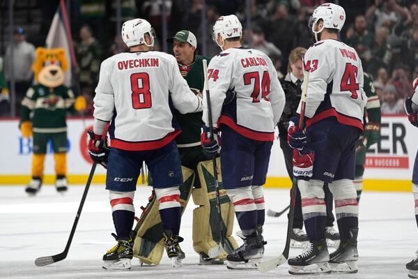 Washington Capitals left wing Alex Ovechkin (8) and Minnesota Wild goaltender Marc-Andre Fleury (29), back, talk after an NHL hockey game, Thursday, March 27, 2025, in St. Paul, Minn. (AP Photo/Abbie Parr)
