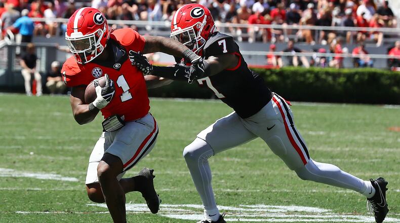 041324 Athens: Georgia running back Trevor Etienne catches a pass and picks up yardage past defensive back Daniel Harris during the G-Day game on Saturday, April 13, 2024.  Curtis Compton for the Atlanta Journal Constitution