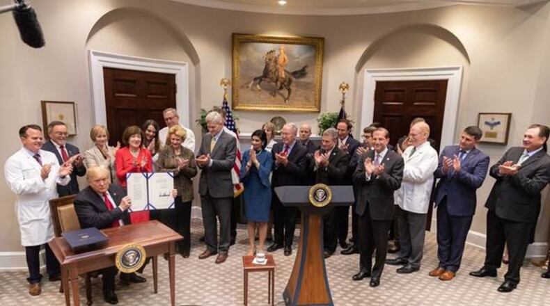 President Donald Trump displays a bill he signed into law Wednesday that outlaws gag clauses that prevent pharmacists from telling patients when they can save money by paying out of pocket. The sponsor of the bill was U.S. Rep. Buddy Carter of Pooler, the only pharmacist serving in Congress. (PHOTO courtesy of the White House)