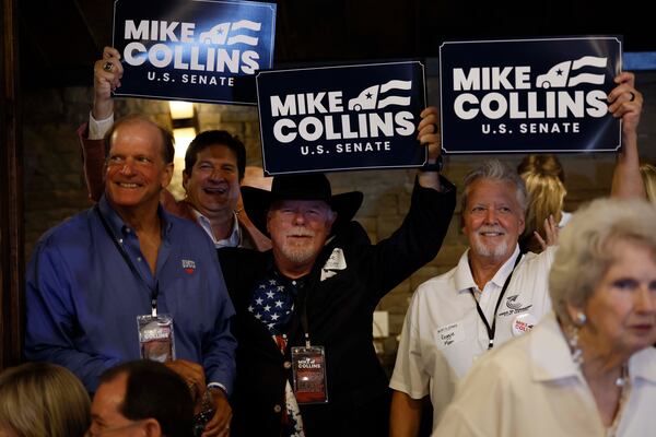 Supporters of U.S. Rep. Mike Collins hold banners during an runoff election night watch last month at Seven Oaks Manor in Jackson.  (Miguel Martinez/AJC)
