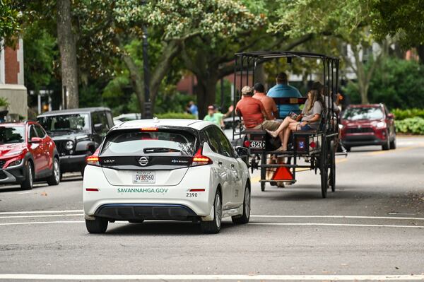 A city of Savannah vehicle follows a horse-drawn carriage down Bull Street in Savannah, Ga., on Aug. 2, 2025. (Sarah Peacock for the AJC)