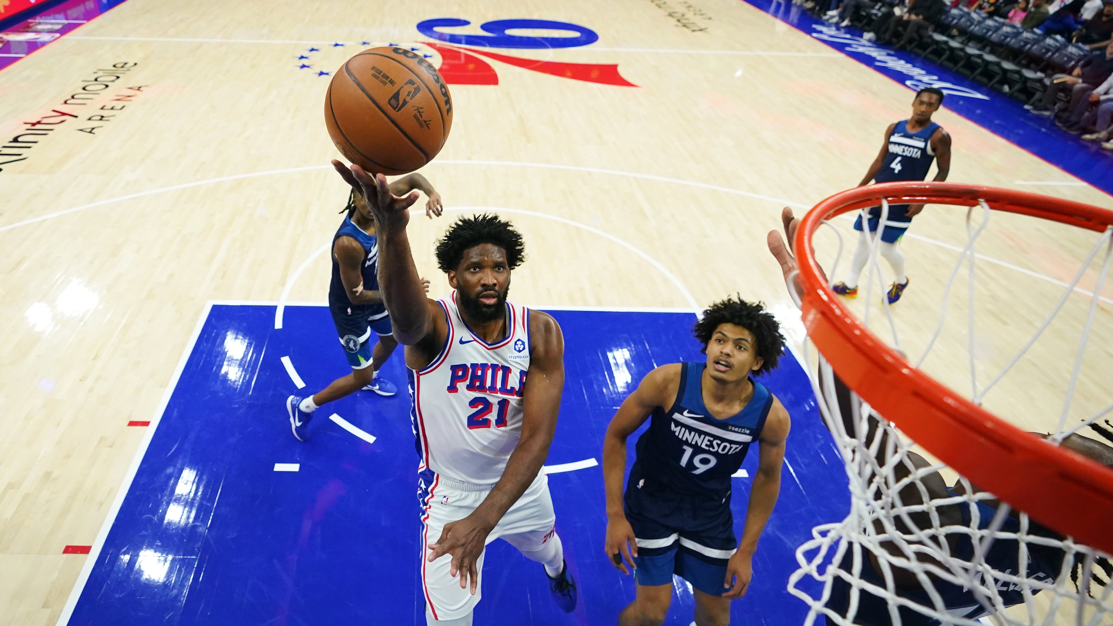 Philadelphia 76ers' Joel Embiid (21) goes up for a shot past Minnesota Timberwolves' Joan Beringer (19) during the first half of an preseason NBA basketball game Friday, Oct. 17, 2025, in Philadelphia. (AP Photo/Matt Slocum)