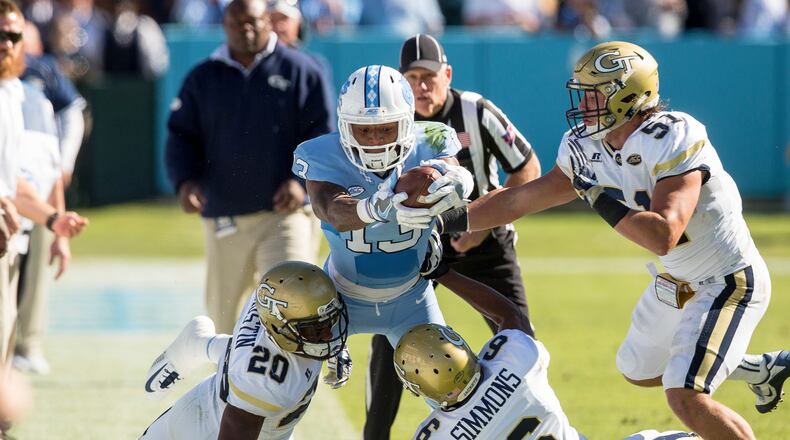 North Carolina’s Bug Howard (13) attempts to stretch for a first down as Georgia Tech’s Lawrence Austin (20), Lamont Simmons (6), and Brant Mitchell (51) defend during the first half of an NCAA college football game Chapel Hill, N.C., Saturday, Nov. 5, 2016. (AP Photo/Ben McKeown)