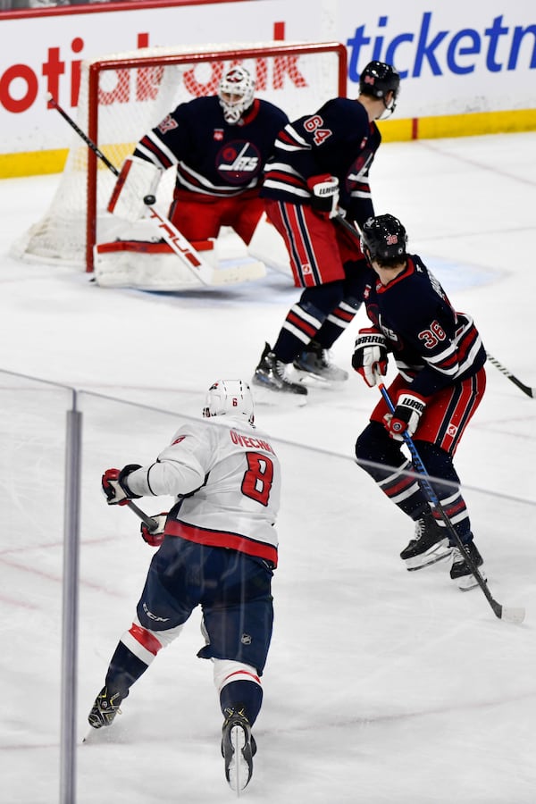 Washington Capitals' Alex Ovechkin (8) takes a shot on Winnipeg Jets goaltender Connor Hellebuyck (37) during the second period of their NHL hockey game in Winnipeg, Manitoba, Tuesday, March 25, 2025. (Fred Greenslade/The Canadian Press via AP)