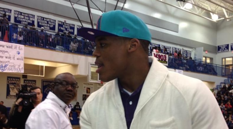 Carolina Panthers quarterback Cam Newton shakes hands with the official scorer before his jersey was retired at Westlake High on Friday night.
