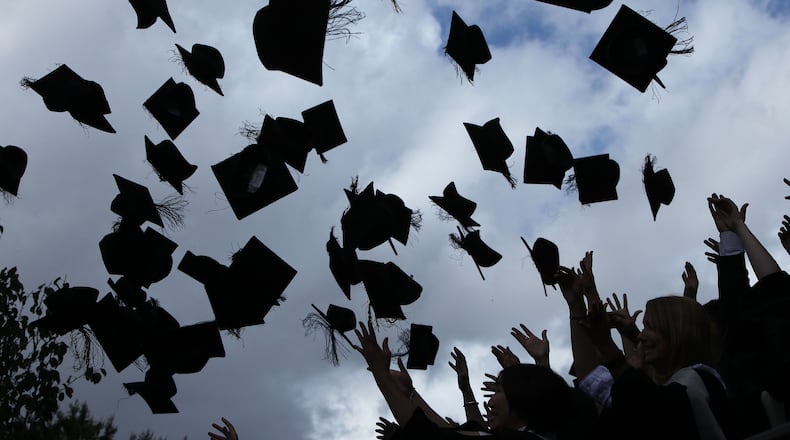 Students throw their caps. (Photo by Christopher Furlong/Getty Images)